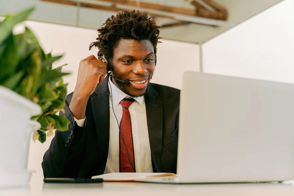 Uśmiechnięty menedżer pracujący przy laptopie w nowoczesnym biurze